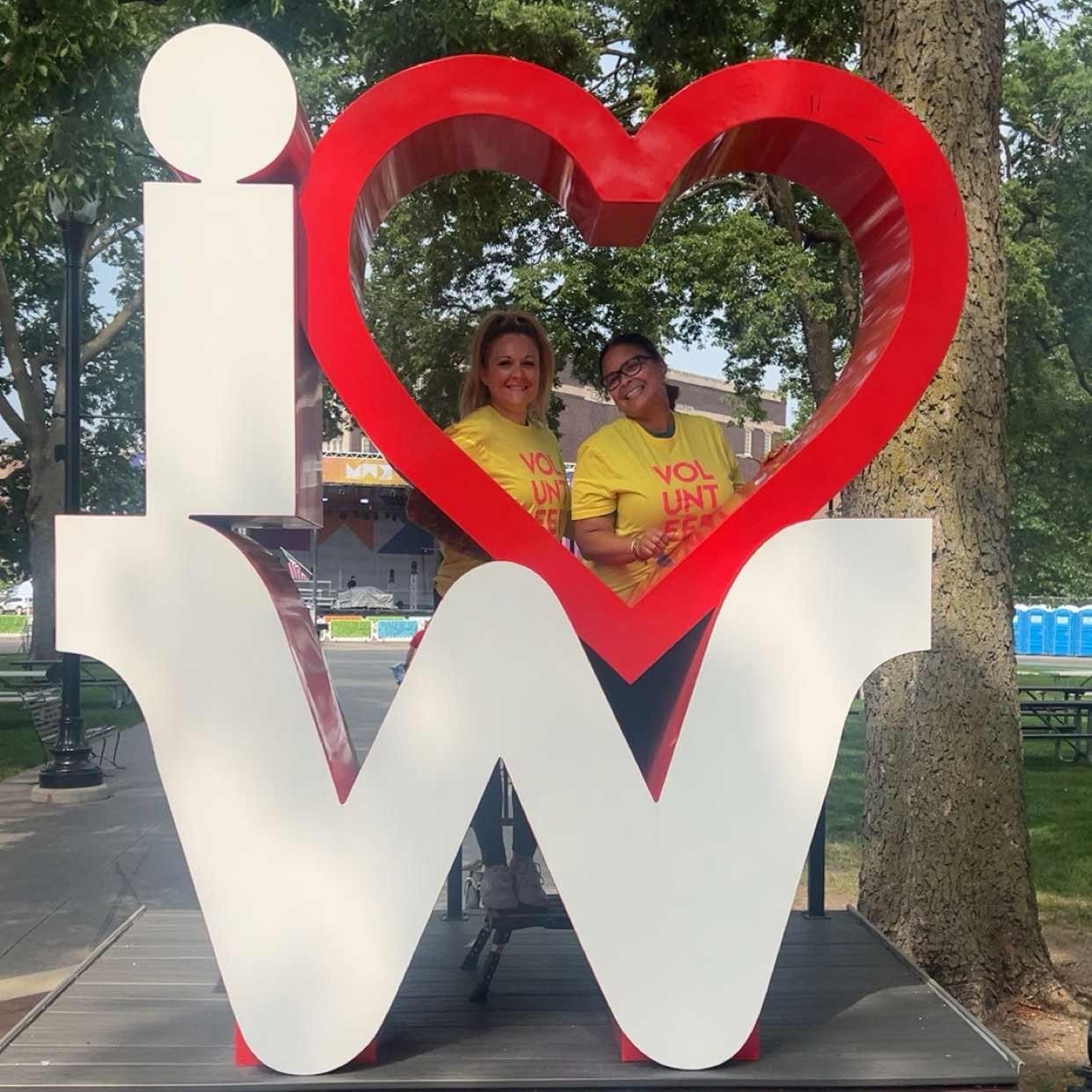 Photo of Dupaco employee Amanda Clark standing behind a sculpture that says: 'I love W.'