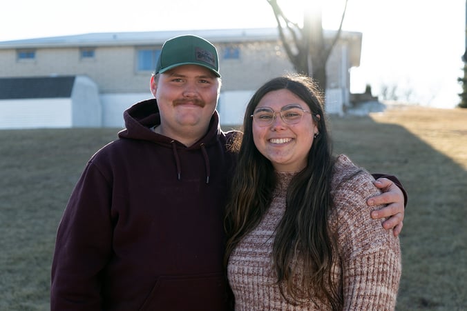 Dupaco members Ben Knepper and Grace Wanke smile as they stand outside their new home.