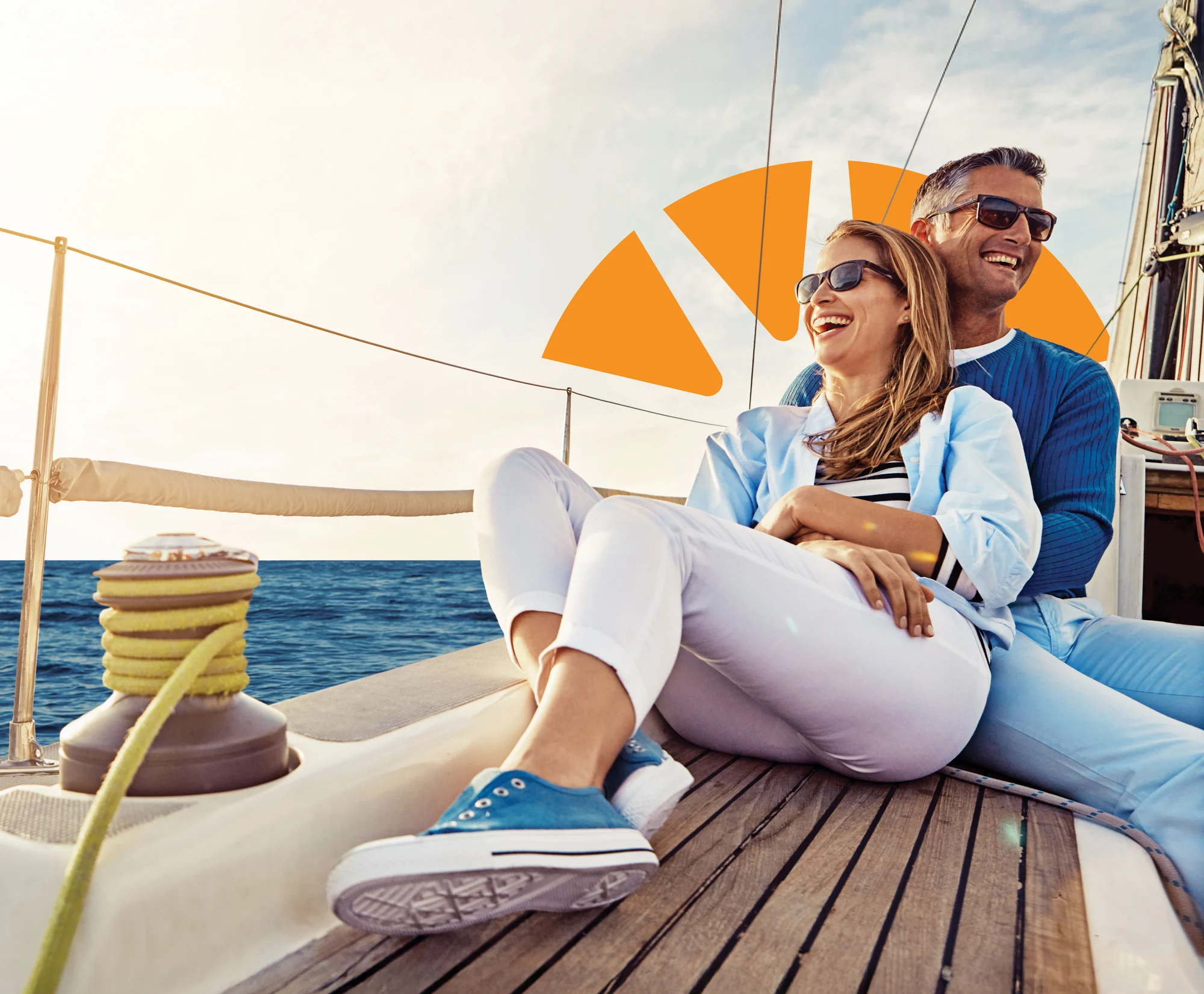 A smiling man and woman sit against each other on a sailboat, with the Dupaco logo behind them in the sky.