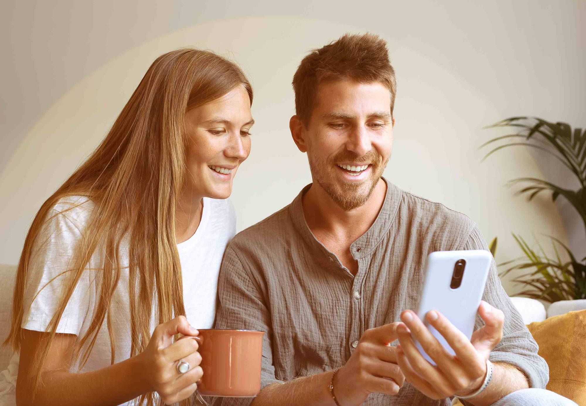 Young-couple-coffee-phone-happy-HGstock-676x338