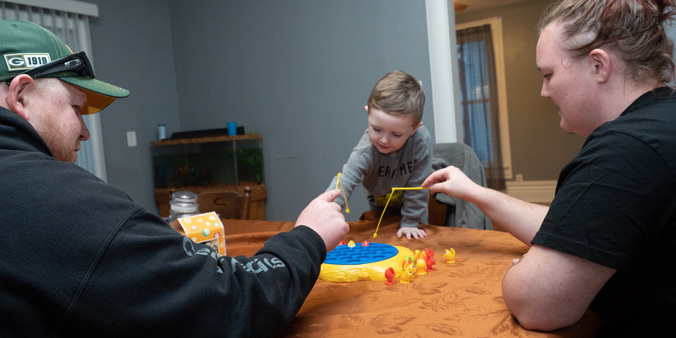 Dupaco member Ryan Bubenyak plays a game with his family at his new home.