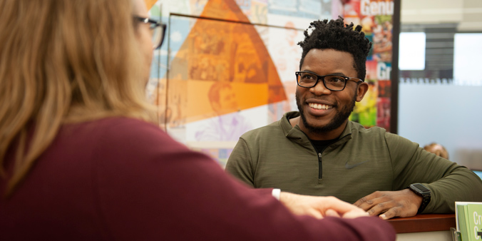 Member Temwa Phiri (right), of Dubuque, Iowa, meets with Dupaco’s James Eppler during his Money Makeover at the credit union’s Hy-Vee branch in Dubuque. (M. Blondin/Dupaco photo)