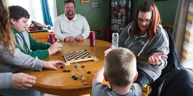 Dupaco members Michael and Jen Graham play a game with their three children at their home in Villisca, Iowa. (A. Mehl photo)