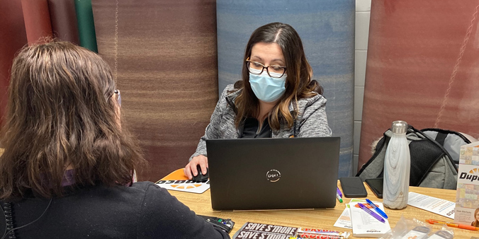 Dupaco’s Melinda Vize (left) talks to a member during a free, on-site financial education opportunity for employees at Bertch Cabinets in Waterloo, Iowa.