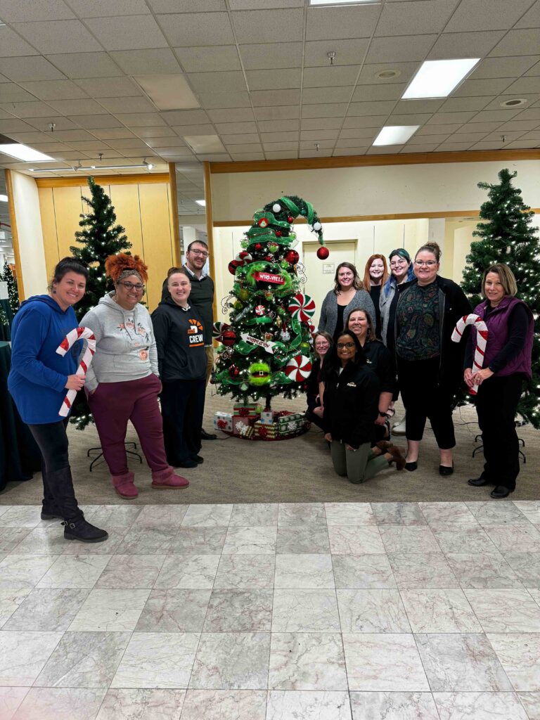 Dupaco employees standing around a tree sponsored by Dupaco at the Festival of the Trees.
