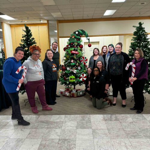 Dupaco employees standing around a tree sponsored by Dupaco at the Festival of the Trees.