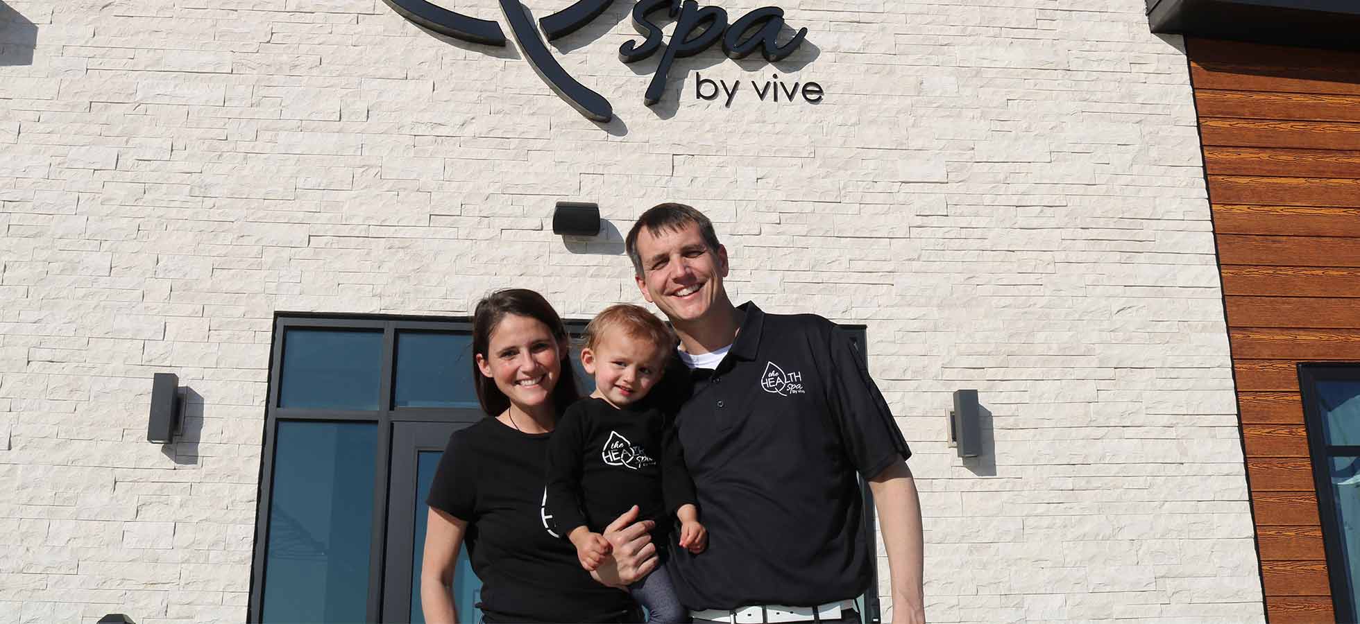 Stephanie Grutz, Alex Goerdt and their daughter Lainey, in front of their new location of The Health Spa