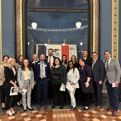 Capitol-Hill-Visit-2025 A group of individuals of various backgrounds stands inside the Iowa Capitol, showcasing camaraderie and community spirit.